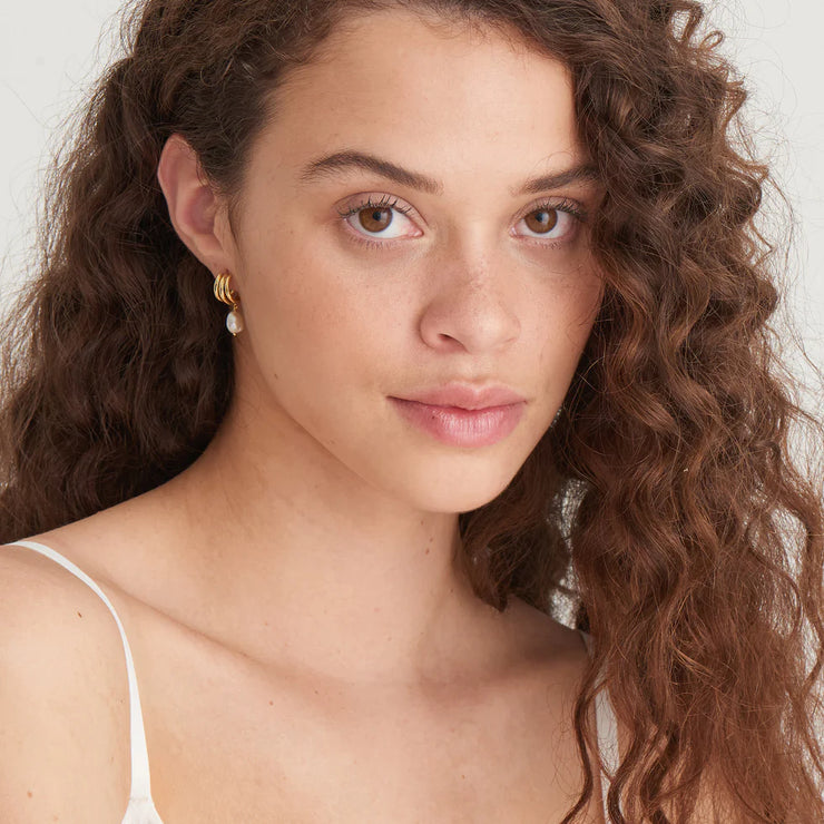 Ania Haie Gold Triple Mini Hoop Pearl Huggies. 14K yellow gold plated on 925 sterling silver. Bichsel Jewelry in Sedalia, MO. Shop online or in-store today!